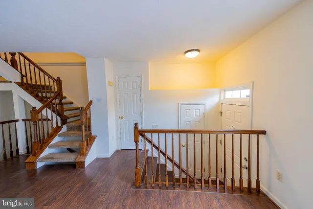 a view of a hallway with wooden floor and staircase