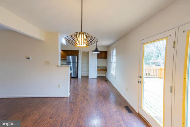 a view of hallway with wooden floor and chandelier