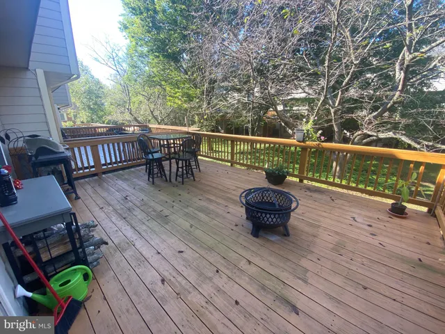 a balcony with wooden floor table and chairs