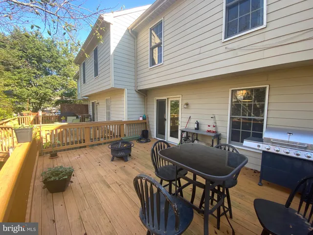 a view of a patio with table and chairs with wooden floor and fence