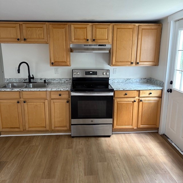 a kitchen with granite countertop a stove sink and cabinets