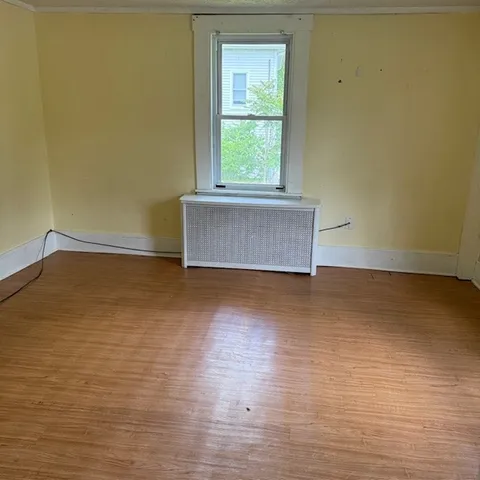 a view of a room with wooden floor and window