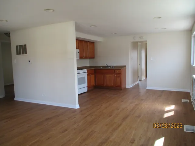 a view with kitchen and wooden floor