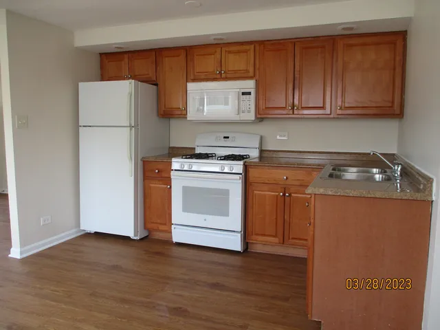 a kitchen with a white stove top oven and refrigerator