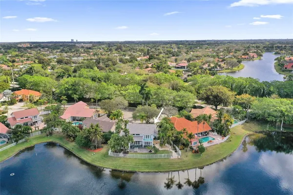 an aerial view of residential houses with outdoor space and lake view