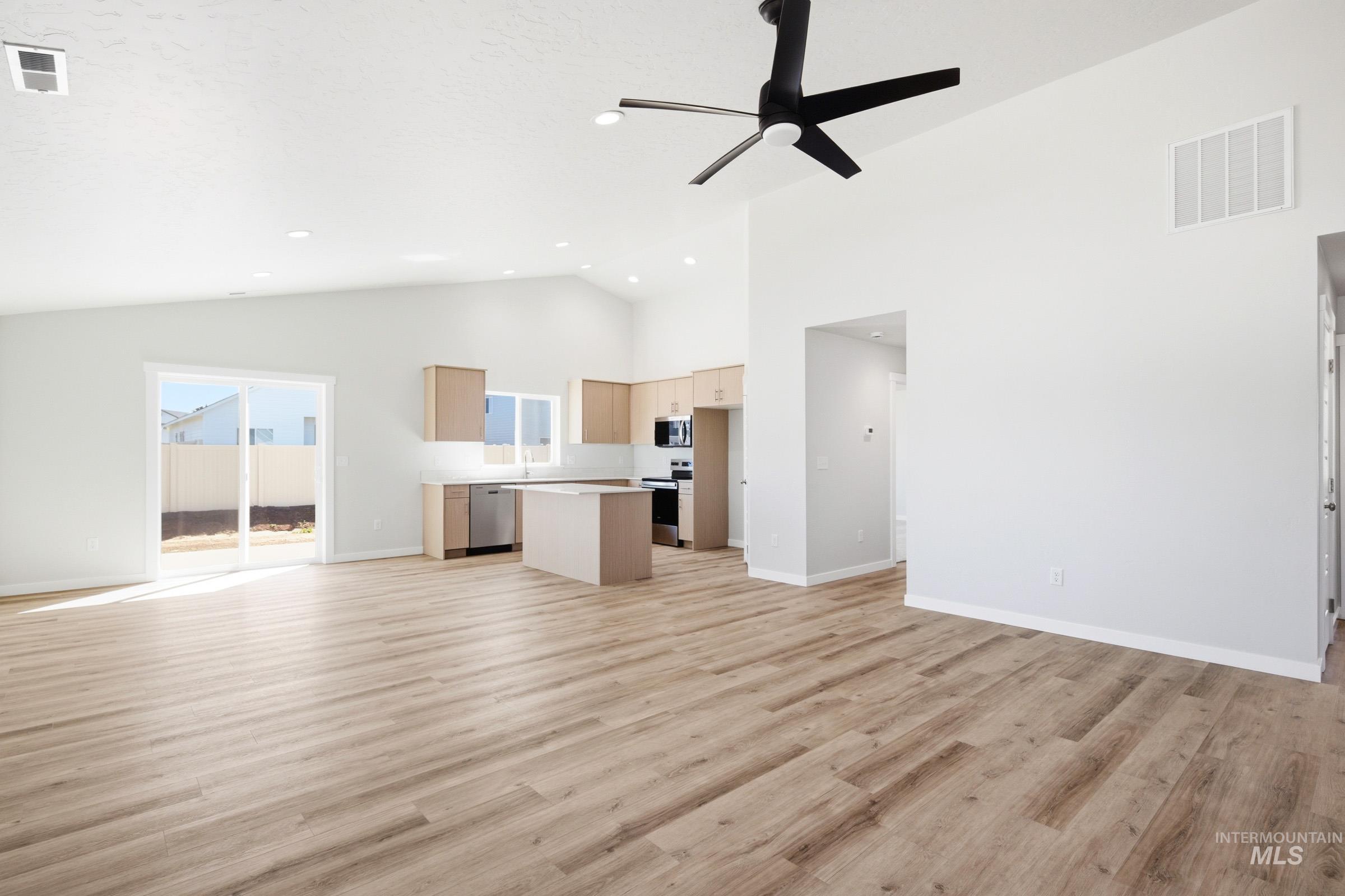 12817 Decatur Street Nampa, ID 83651 - Photo 8 of 19 Open-concept living area featuring vaulted ceilings, wood-finish flooring, a modern ceiling fan, and recessed lighting