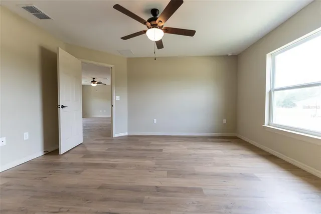 an empty room with fan and windows