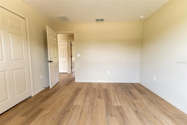 a view of a room with wooden floor and a bathroom