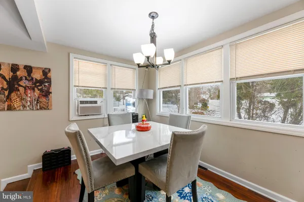 a view of a dining room with furniture a chandelier and wooden floor
