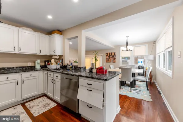 a kitchen with granite countertop a sink stove and cabinets