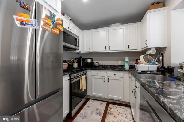 a kitchen with stainless steel appliances granite countertop a refrigerator and a stove top oven