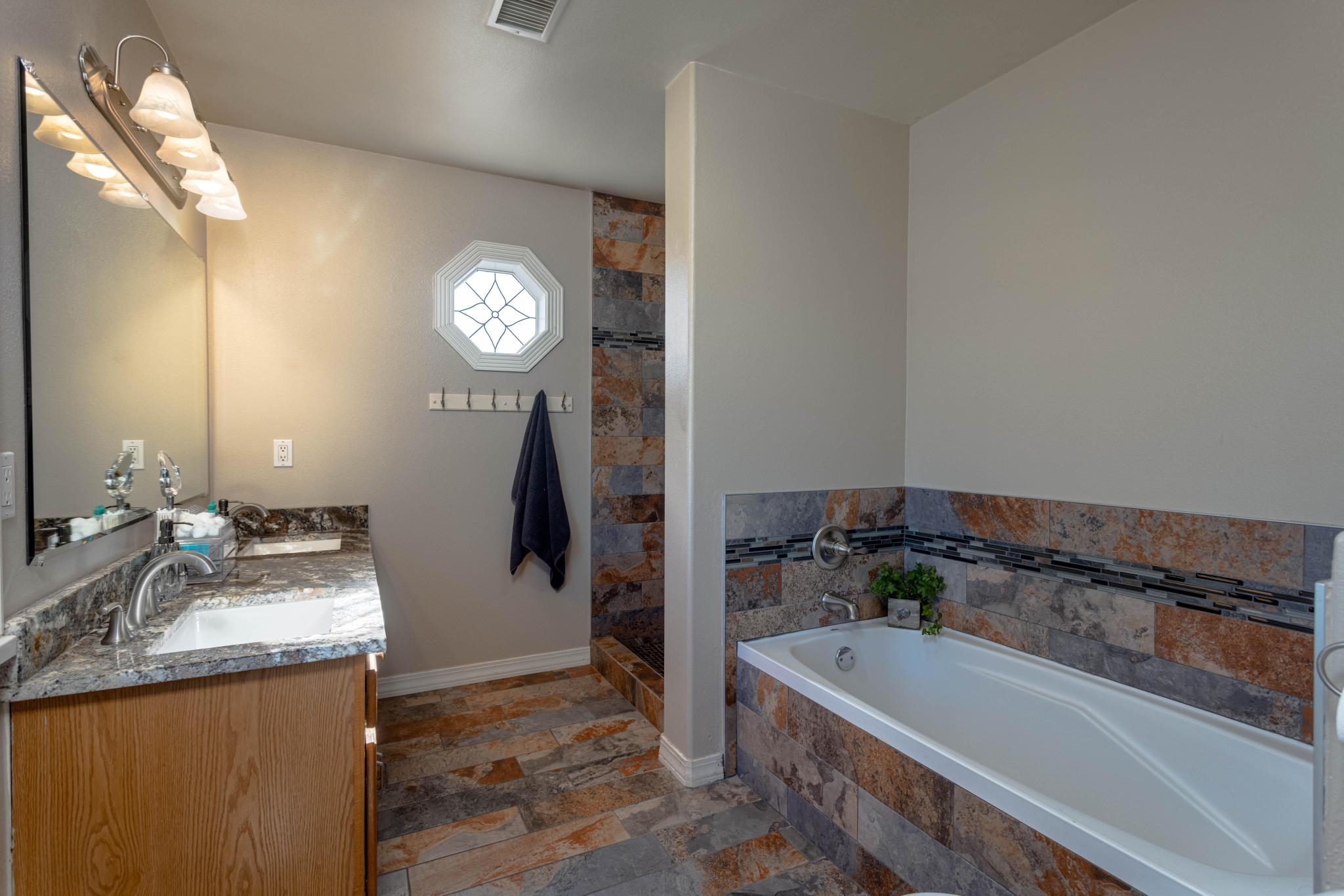1168 Windsor Park Drive Fruita, CO 81521 - Photo 39 of 41 a spacious bathroom with a granite countertop tub sink and mirror