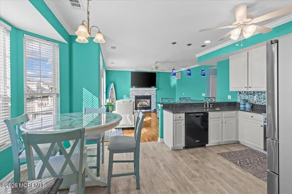 a kitchen with stainless steel appliances granite countertop a stove top oven a sink dishwasher and a refrigerator with wooden floor