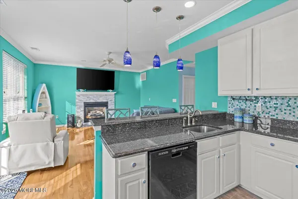 a kitchen with granite countertop a sink and a stove top oven