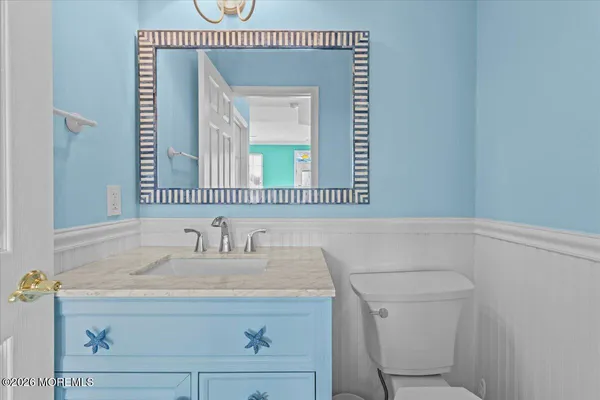 a bathroom with a toilet a sink and mirror