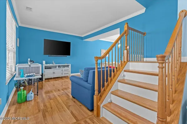 a view of a livingroom with wooden floor and furniture