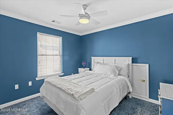 a bedroom with a large bed and a ceiling fan