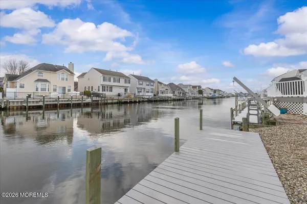 a view of a house next to a lake with houses