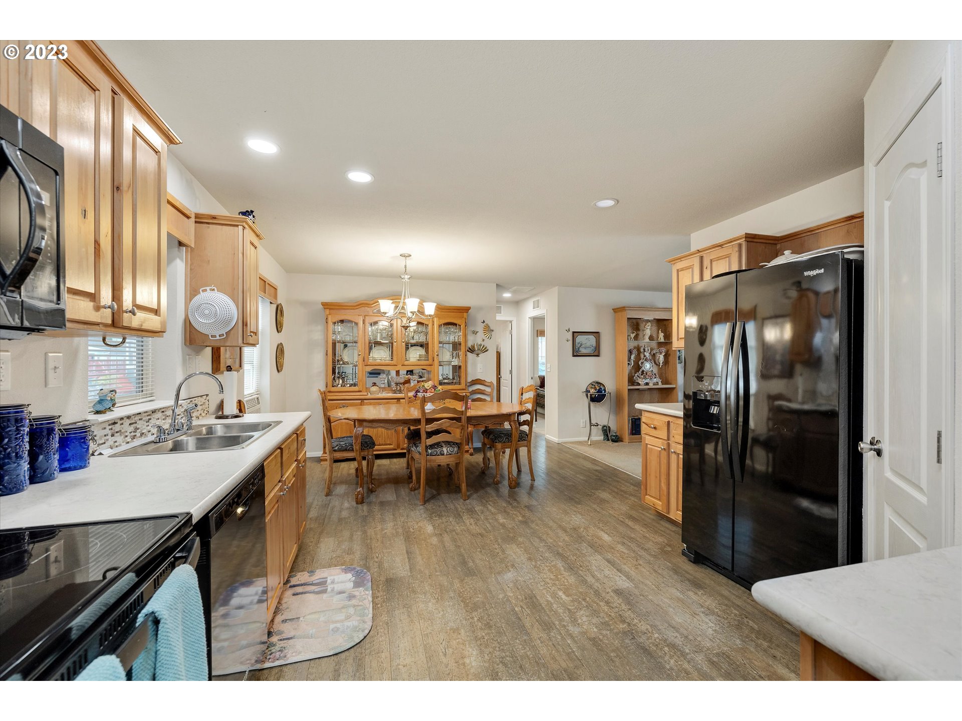 25222 East Welches Road, Unit 46 Welches, OR 97067 - Photo 13 of 30 a kitchen with stainless steel appliances kitchen island granite countertop a refrigerator a sink a stove and oven with wooden floor