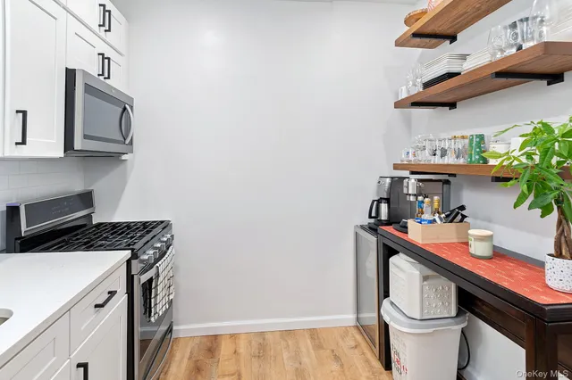 a utility room with stainless steel appliances a sink a stove and cabinets