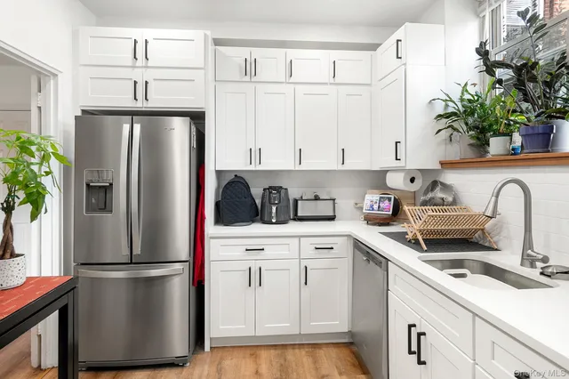 a kitchen with a refrigerator sink and cabinets