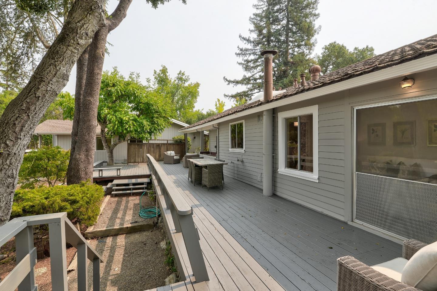 148 Bardet Road Woodside, CA 94062 - Photo 19 of 39 a view of a patio with table and chairs with wooden floor and fence