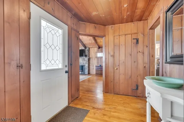 a view of a hallway with wooden floor and cabinet