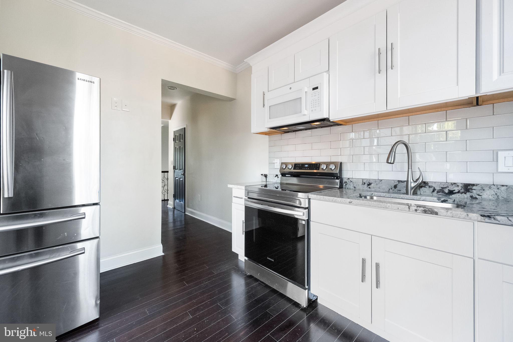 6709 Benson Drive Alexandria, VA 22306 - Photo 38 of 66 a kitchen with granite countertop white cabinets and stainless steel appliances