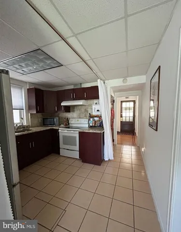 a large kitchen with stainless steel appliances granite countertop a stove a sink dishwasher and a refrigerator