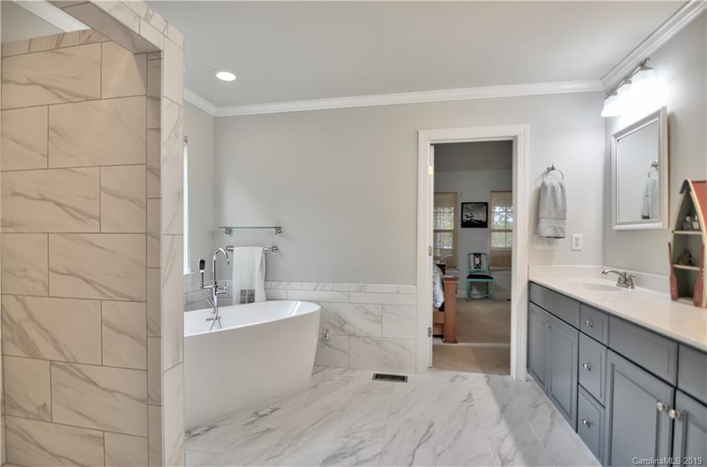 20210 Bascom Ridge Drive Cornelius, NC 28031 - Photo 17 of 35 a bathroom with a tub sink a mirror and a shower