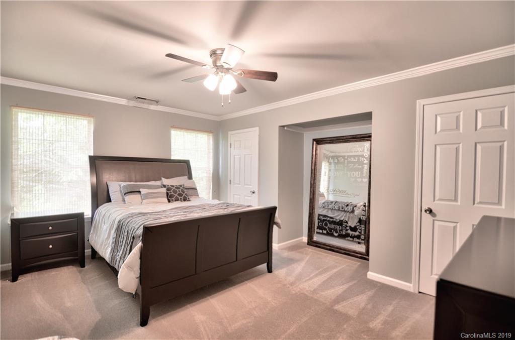 20210 Bascom Ridge Drive Cornelius, NC 28031 - Photo 20 of 35 a bedroom with a bed and a chandelier