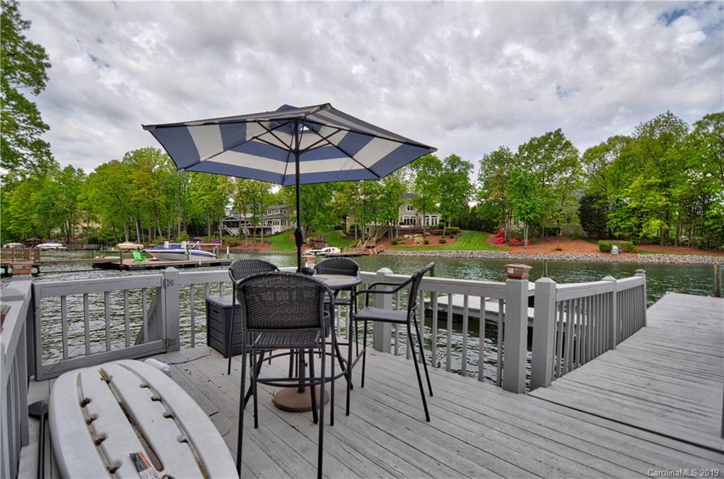 20210 Bascom Ridge Drive Cornelius, NC 28031 - Photo 32 of 35 a view of a patio with table and chairs under an umbrella with wooden floor