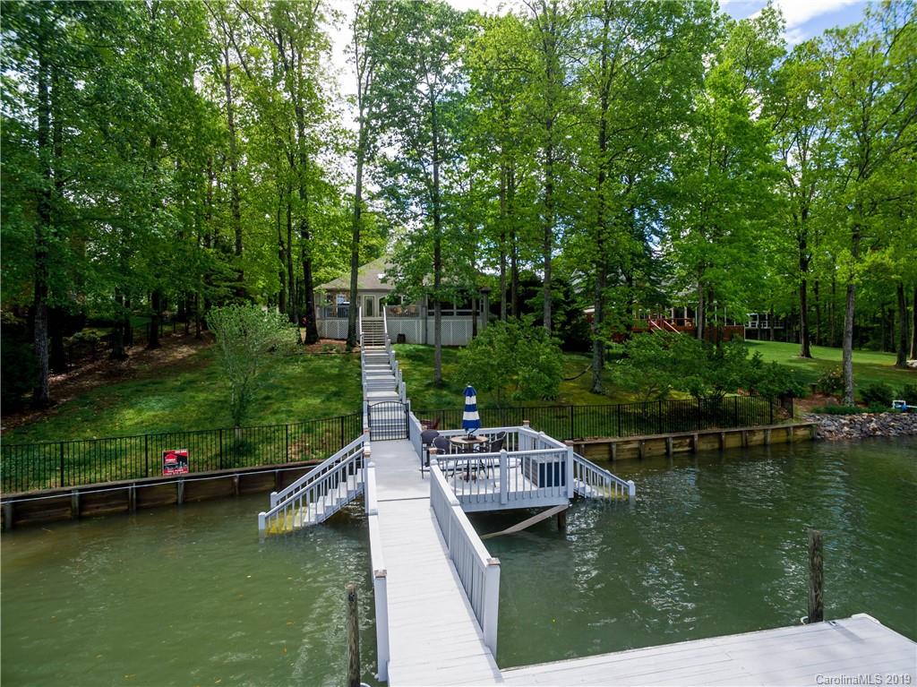 20210 Bascom Ridge Drive Cornelius, NC 28031 - Photo 34 of 35 a wooden deck with river and trees in the background