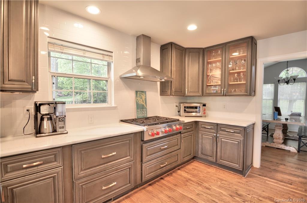 20210 Bascom Ridge Drive Cornelius, NC 28031 - Photo 6 of 35 a kitchen with kitchen island granite countertop a sink cabinets and window