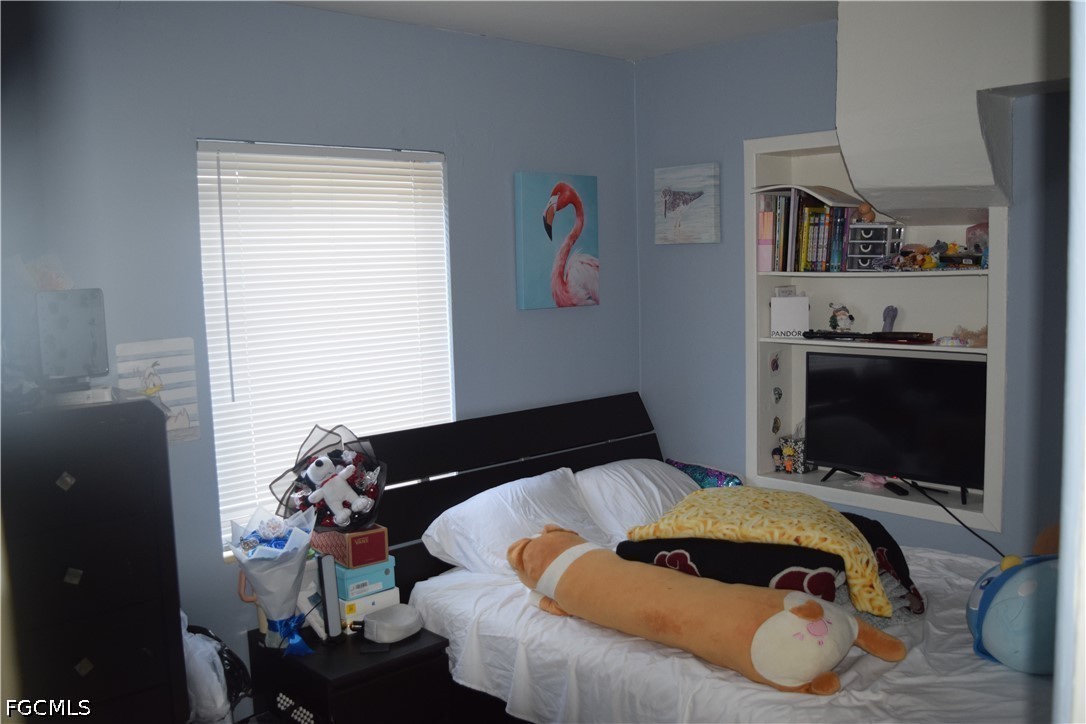 17 Colorado Road Lehigh Acres, FL 33936 - Photo 14 of 17 a bedroom with a bed and a flat screen tv