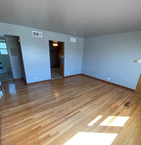 a view of an empty room and wooden floor