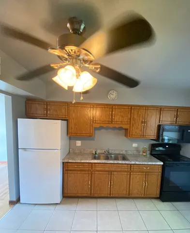 a kitchen with granite countertop a refrigerator a stove and a sink