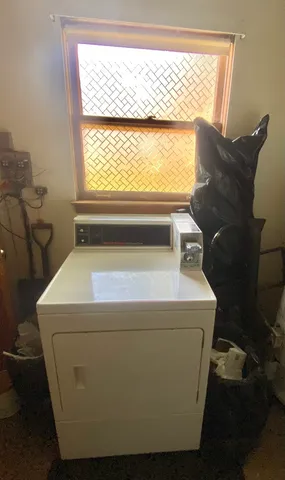 a utility room with dryer and window