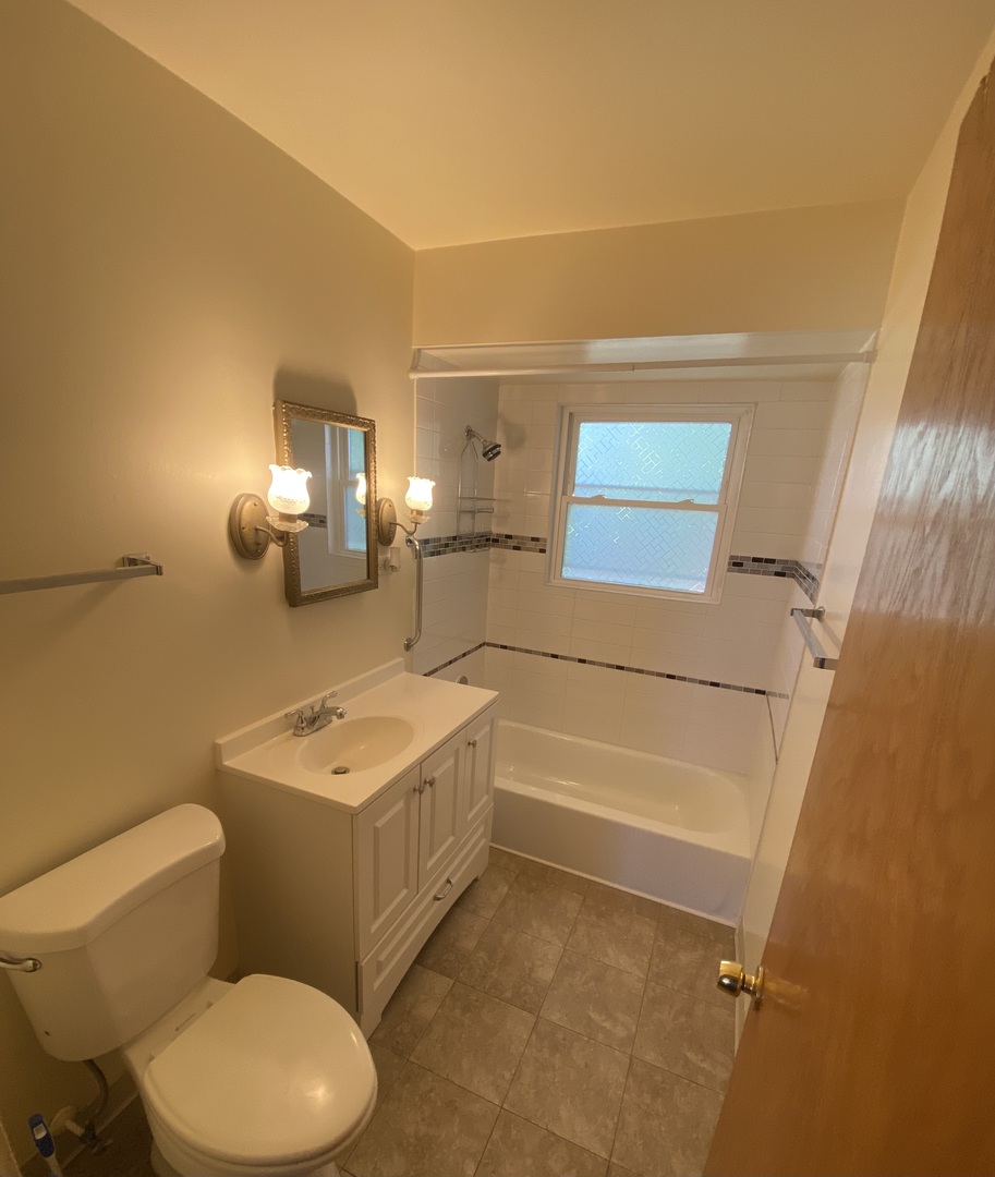 18231 Morgan Avenue, Unit 2N Homewood, IL 60430 - Photo 6 of 28 a bathroom with a toilet a sink and a mirror