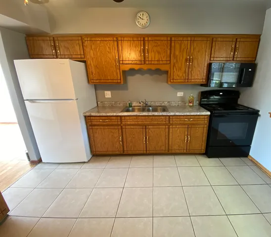 a kitchen with stainless steel appliances granite countertop a sink a stove a refrigerator a microwave and cabinets