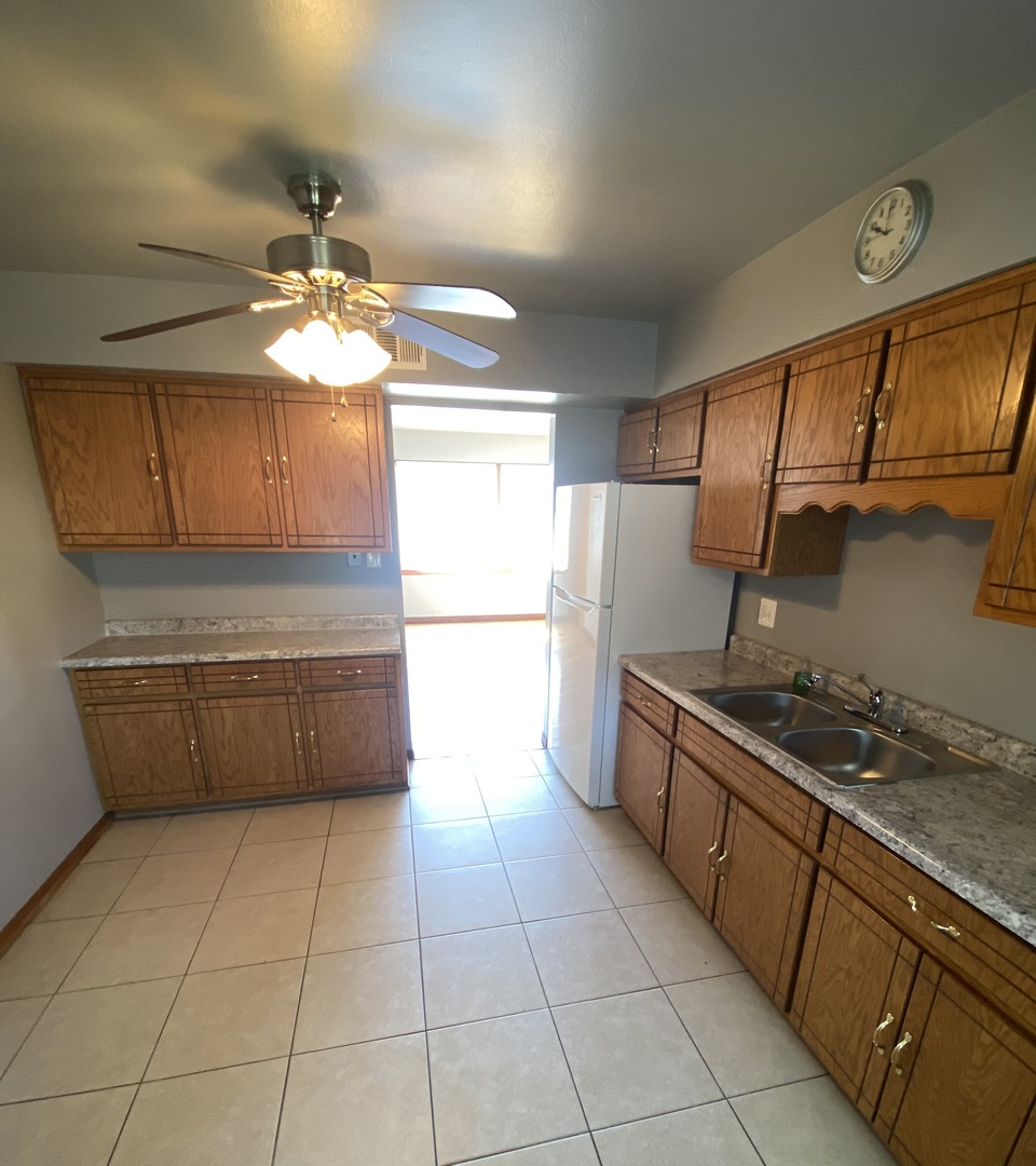 18231 Morgan Avenue, Unit 2N Homewood, IL 60430 - Photo 10 of 28 a kitchen with stainless steel appliances granite countertop a sink counter space cabinetry and a chandelier