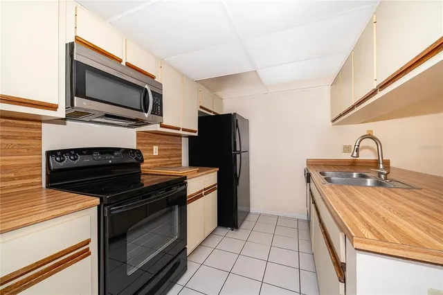 a kitchen with stainless steel appliances a stove microwave and sink