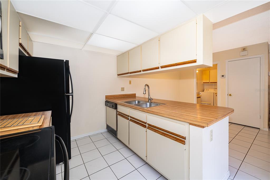 5258 Coral Court, Unit 605 Orlando, FL 32811 - Photo 17 of 41 a kitchen with stainless steel appliances granite countertop a sink stove and refrigerator