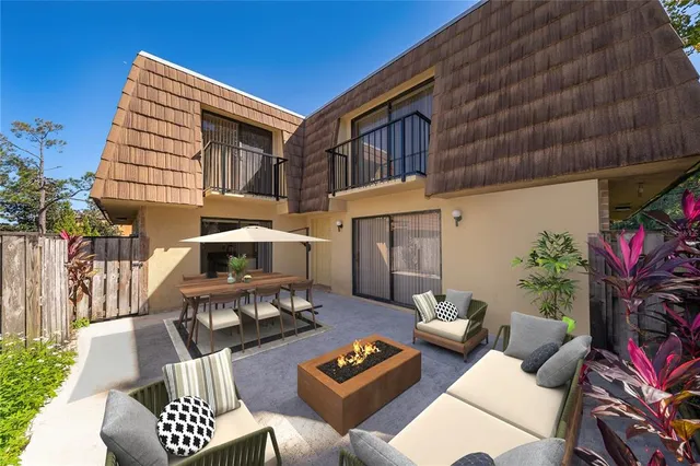 a view of a patio with couches table and chairs and potted plants