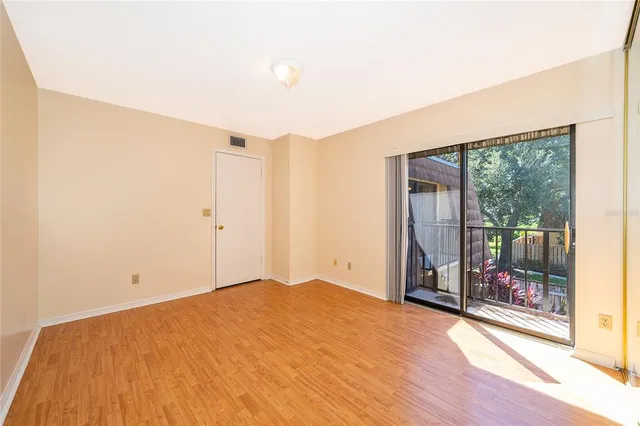 a view of empty room with wooden floor
