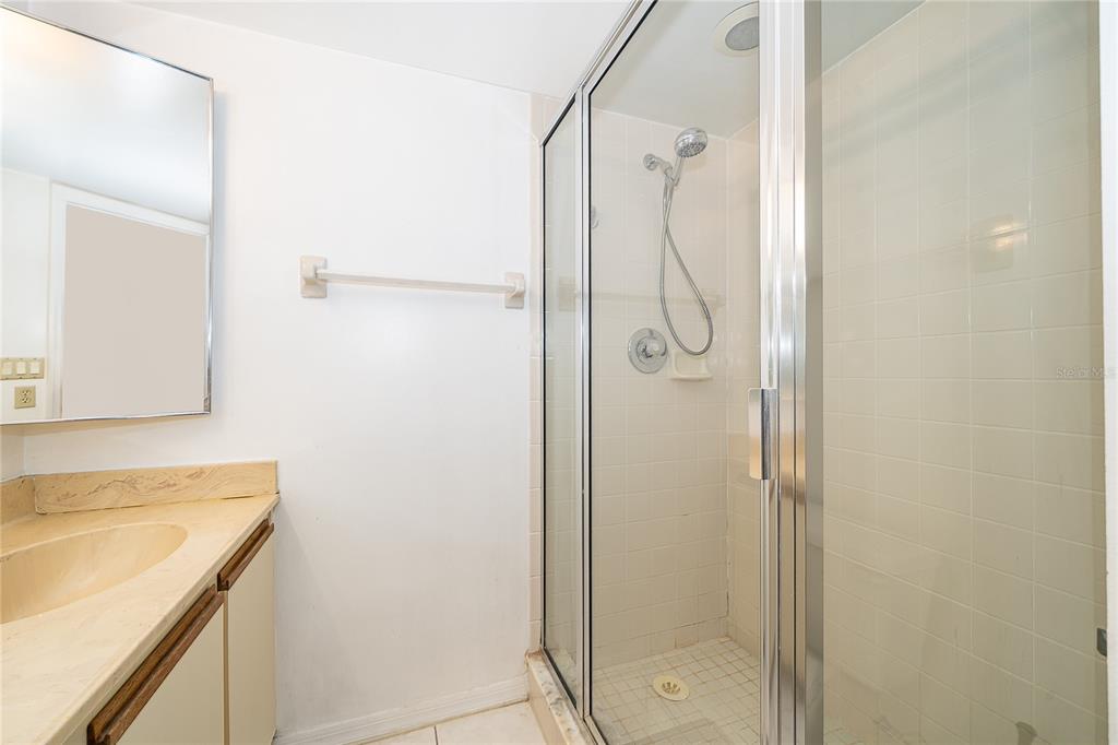 5258 Coral Court, Unit 605 Orlando, FL 32811 - Photo 25 of 41 a bathroom with a granite countertop shower mirror and a sink