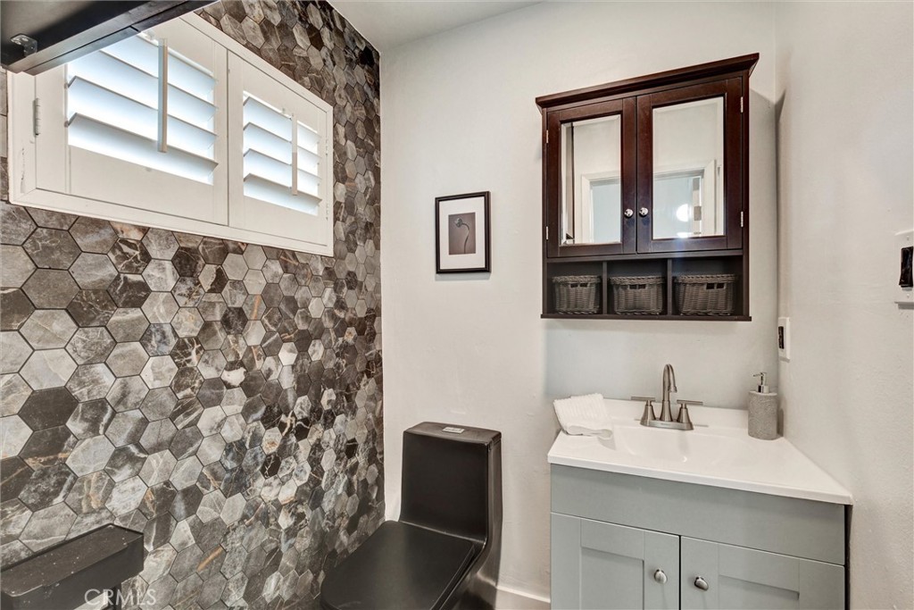 1401 West 165th Street Compton, CA 90220 - Photo 24 of 31 a bathroom with a sink a mirror and a window