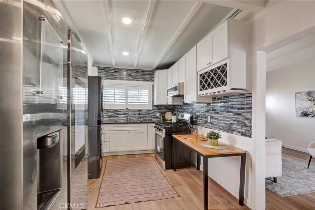 1401 West 165th Street Compton, CA 90220 - Photo 8 of 31 a kitchen with a refrigerator a sink and a stove top oven