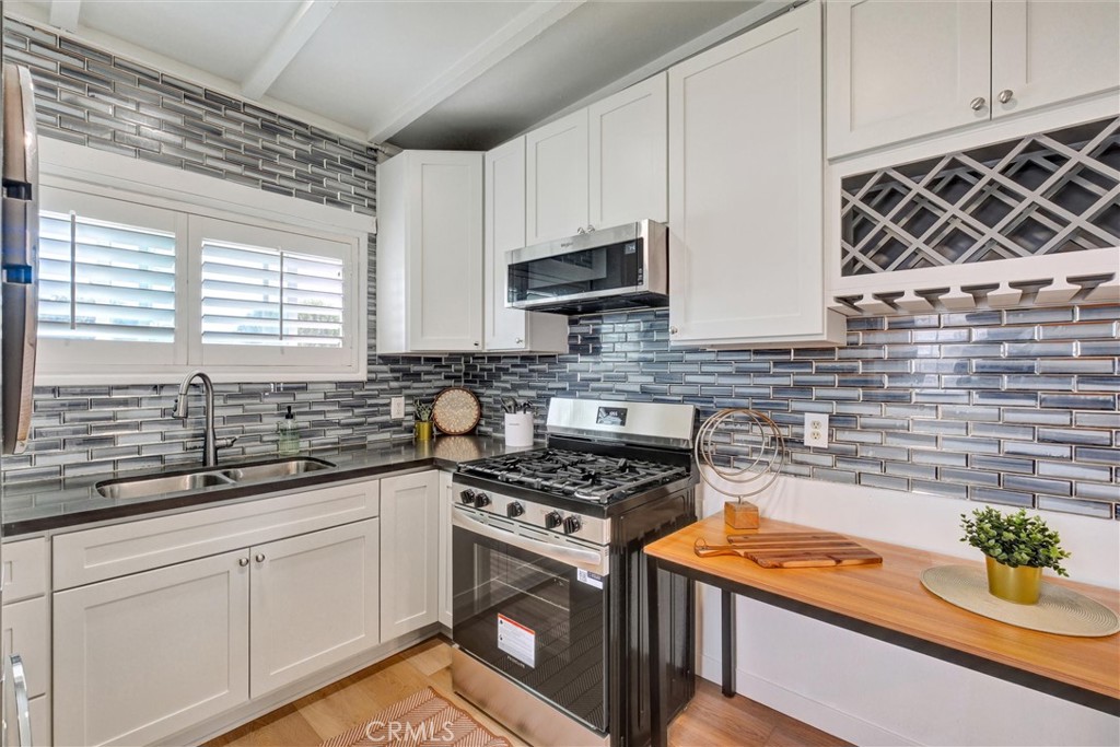 1401 West 165th Street Compton, CA 90220 - Photo 9 of 31 a kitchen with stainless steel appliances a stove a sink and a white cabinets