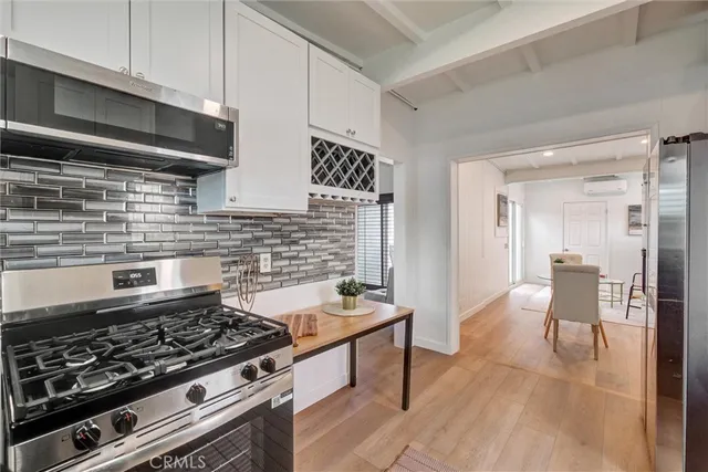 a kitchen with stainless steel appliances a stove a table and chairs